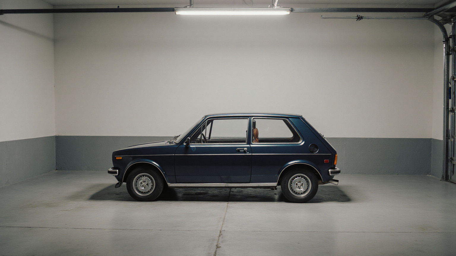 An unbranded car parked in a plain garage without signs or plates